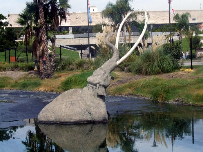 A statue of an elephant stuck in a tar pit