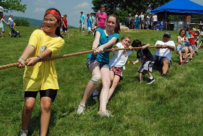 A number of children playing tug of war