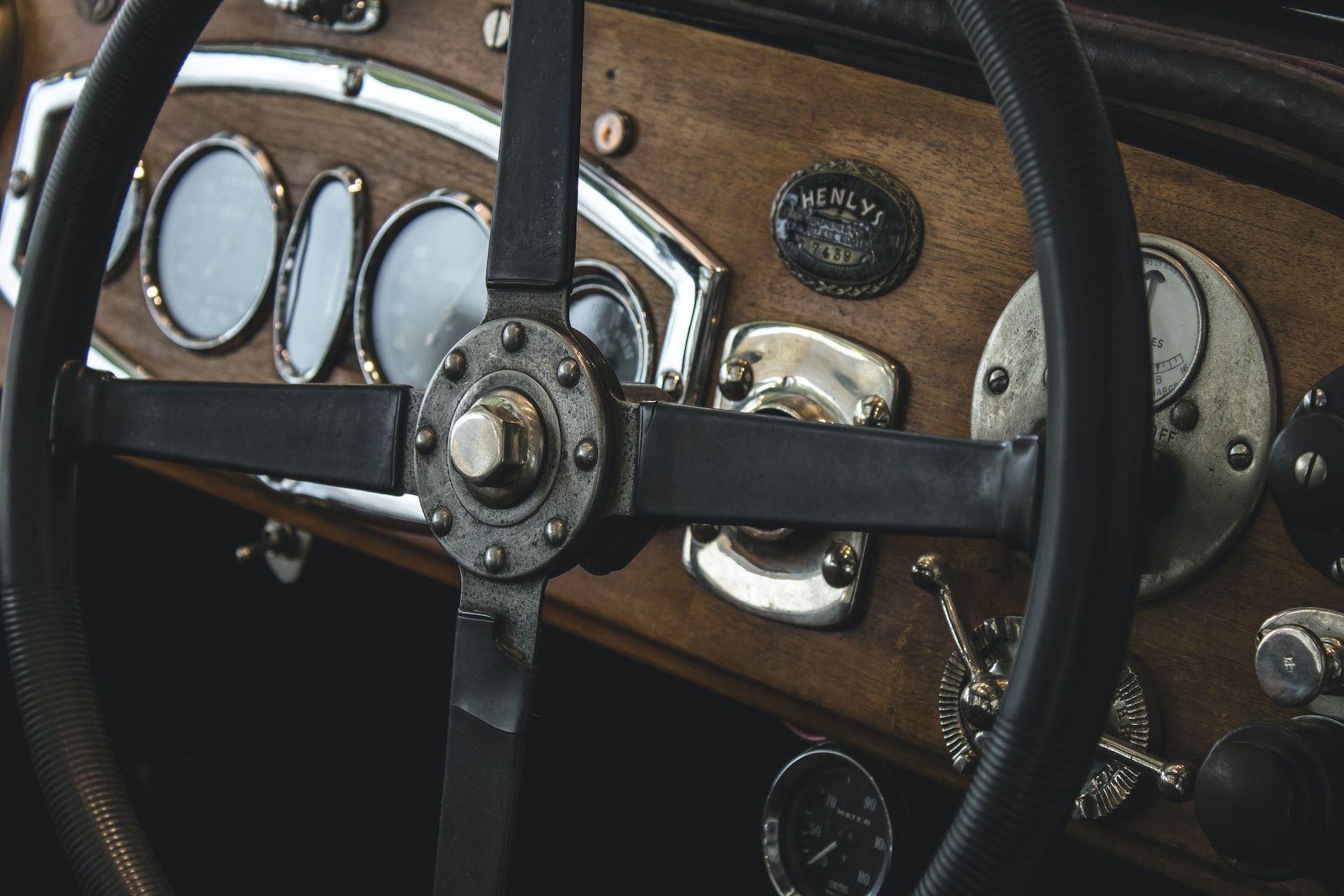 A vintage car's steering wheel and dashboard